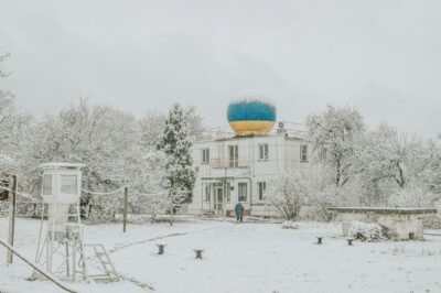 White building with a blue and yellow dome in snow
