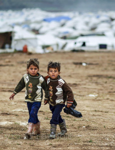 Syrian boys, whose family fled their home in Idlib, walk to thei