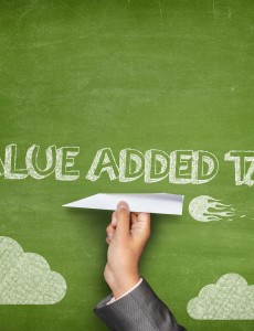 Value added tax concept on blackboard with paper plane